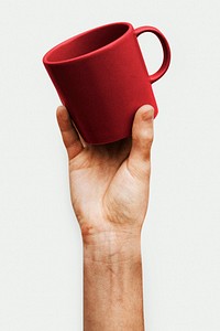 Hand holding a red ceramic coffee cup
