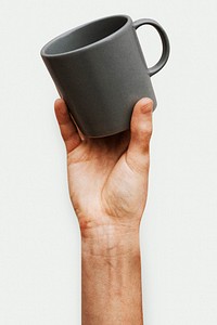 Hand holding a gray ceramic coffee cup
