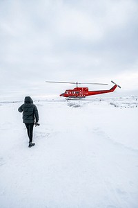 Landscape photographer walking to a red helicopter