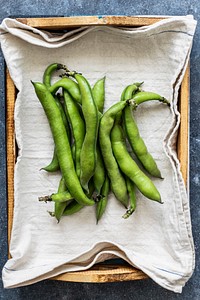 Fresh organic broad beans in a wooden box aerial view