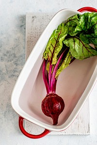 Fresh organic beetroot with leaves  in a white bowl aerial view