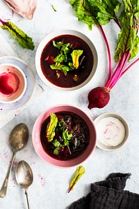 Bowls of healthy beetroot leaf soup with cream on a table food photography