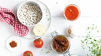 Raw white beans in a bowl by sun-dried tomatoes