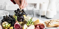 Woman preparing cheese platter and bread sandwiches