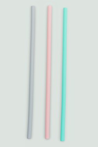 Reusable colorful plastic straws on off white background