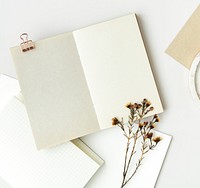 Blank white notebook with dried plant