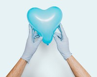 Gloved hands holding a blue heart shaped balloon mockup on a blue background