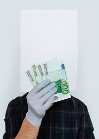 Gloved hand holding a blank paper mockup with banknotes