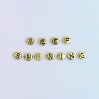 gold KEEP SHINNING beads word typography on pastel