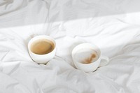 Two cups of coffee on the bed