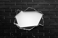 Torn paper on a brick wall