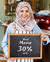 Muslim female entrepreneur holding a sale sign