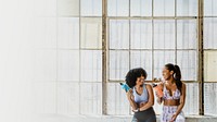 Sportive women talking in a gym while drinking water