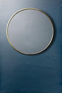 Gold framed mirror on a blue wall