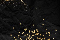 Gold glitter on a black crumpled paper background