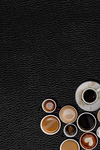 Various coffee mugs on a black leather textured wallpaper