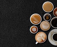 Various coffee mugs on a black leather textured wallpaper