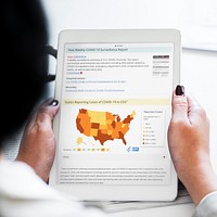 Woman reading coronavirus updates from a tablet mockup with editorial graphic from <a href="https://www.cdc.gov/coronavirus/2019-ncov/cases-updates/cases-in-us.html">https://www.cdc.gov/coronavirus/2019-ncov/cases-updates/cases-in-us.html</a> accessed on April 8th 2020. BANGKOK, THAILAND - JANUARY 19, 2018