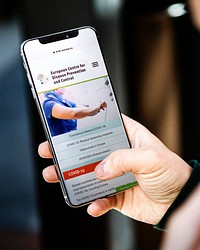 Man reading coronavirus information from a phone mockup with editorial graphic from <a href="https://www.ecdc.europa.eu/en">https://www.ecdc.europa.eu/en</a> accessed on April 8th 2020. BANGKOK, THAILAND - JANUARY 19, 2018