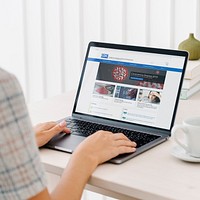 Woman reading coronavirus updates from a laptop mockup with editorial graphic from <a href="https://www.cdc.gov/" target="_blank">https://www.cdc.gov</a> accessed on April 8th 2020. BANGKOK, THAILAND - JULY 17, 2018
