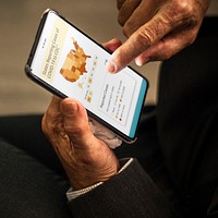 Businessman reading coronavirus updates from a mobile mockup with editorial graphic from <a href="https://www.cdc.gov/coronavirus/2019-ncov/cases-updates/cases-in-us.html">https://www.cdc.gov/coronavirus/2019-ncov/cases-updates/cases-in-us.html</a> accessed on April 8th 2020. BANGKOK, THAILAND - MARCH 28, 2018