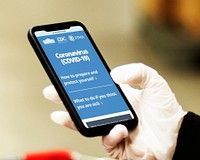 Woman reading coronavirus information from a phone mockup with editorial graphic from <a href="https://www.coronavirus.gov/">https://www.coronavirus.gov/</a> accessed on April 8th 2020. BANGKOK, THAILAND - JANUARY 19, 2018
