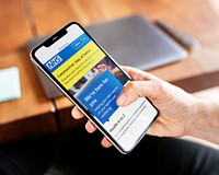Woman reading coronavirus updates from a mobile phone mockup with editorial graphic from <a href="https://www.nhs.uk/" target="_blank">https://www.nhs.uk</a> accessed on April 8th 2020. LOS ANGELES, USA - APRIL 28, 2019