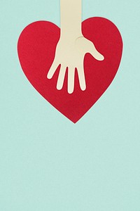 Paper craft hand with a heart supporting donations during coronavirus pandemic background