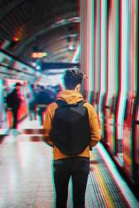 Man with a backpack walking in an underground tube 
