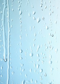 Rain drops on glass blue background 