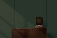 Vintage vinyl record player on wooden sideboard in green wall background