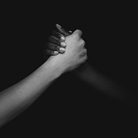 Two diverse people holding hands photo closeup black and white