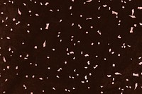 Pink confetti on a brown marble textured background