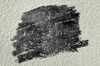 Black oil paint texture on a beige concrete wall