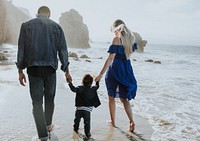 Interracial family walking along the beach in California