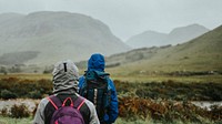 Couple trekking through the rain in the Highlands