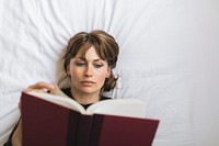 Woman reading a book on a bed during coronavirus quarantine