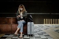 Woman looking at her watch while waiting for the train during the coronavirus pandemic