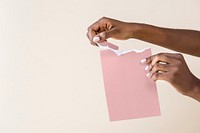 Black woman tearing a pink paper 