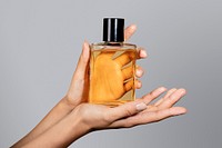 Woman holding a perfume glass bottle psd