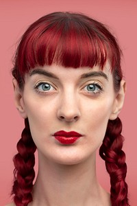 Beautiful woman with braided red hair headshot on a blank pink wall