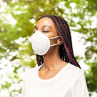 Black woman wearing an air pollution mask in a park