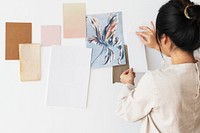 Asian woman attaching a plain white paper to a wall