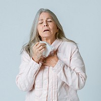 Coronavirus infected senior woman sneezing in a tissue paper