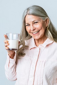 Cheerful senior woman drinking a glass of milk