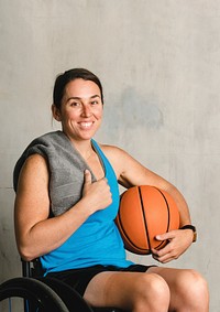 Happy female athlete in a wheelchair with a basketball 