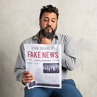 Doubtful Indian man reading the newspaper with fake news<br /> 