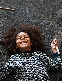 Happy African American girl lying on the floor