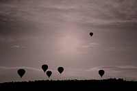 Silhouettes of hot air balloons fly across the sky. Original public domain image from <a href="https://commons.wikimedia.org/wiki/File:Hot_Air_Balloon_Silhouettes_(Unsplash).jpg" target="_blank" rel="noopener noreferrer nofollow">Wikimedia Commons</a>