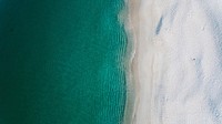 Drone view of a clear ocean washing up on sand shore in Nelson Bay. Original public domain image from <a href="https://commons.wikimedia.org/wiki/File:Drone_view_of_ocean_waves_1_(Unsplash).jpg" target="_blank" rel="noopener noreferrer nofollow">Wikimedia Commons</a>